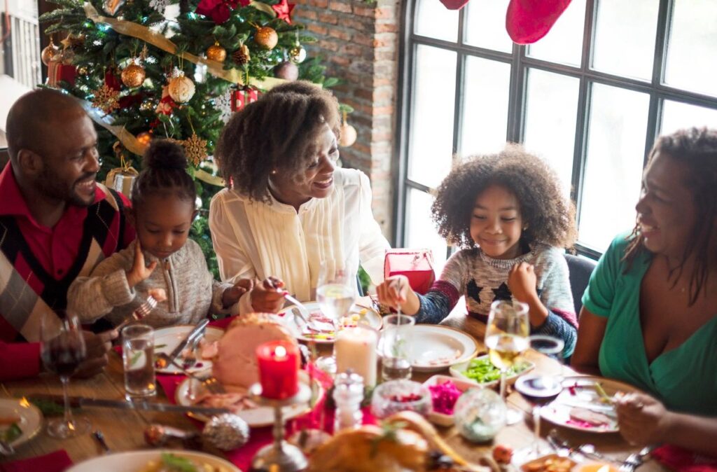 Family at table with Christmas tree in background