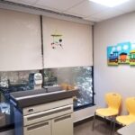 Exam room with pediatric exam table. white walls. gray floor.