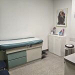 Exam room with exam table, gray floors, and white walls