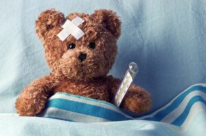 Teddy bear with bandage and thermometer.