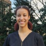 Medical assistant with black scrub top and hair pulled back