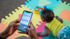 Preventive Care 10 Baby on playmat while Mom holds cellphone